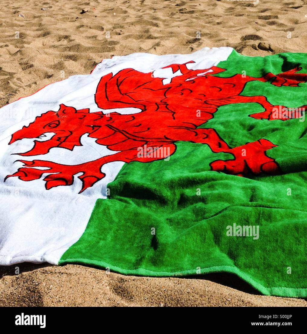Red Welsh Dragon Flag towel on beach Stock Photo