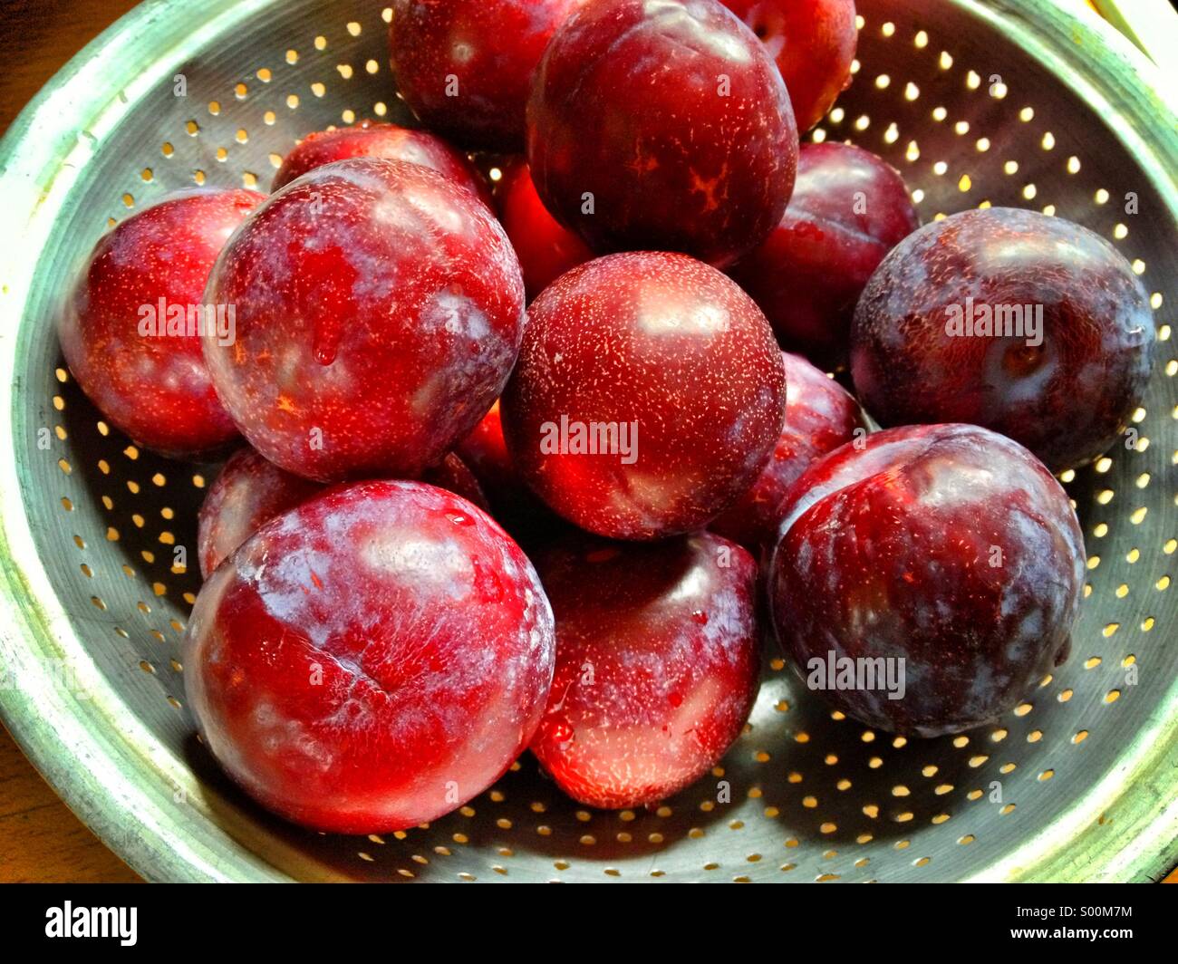 Red plums in colander. - Smartphone Captured Stock Image