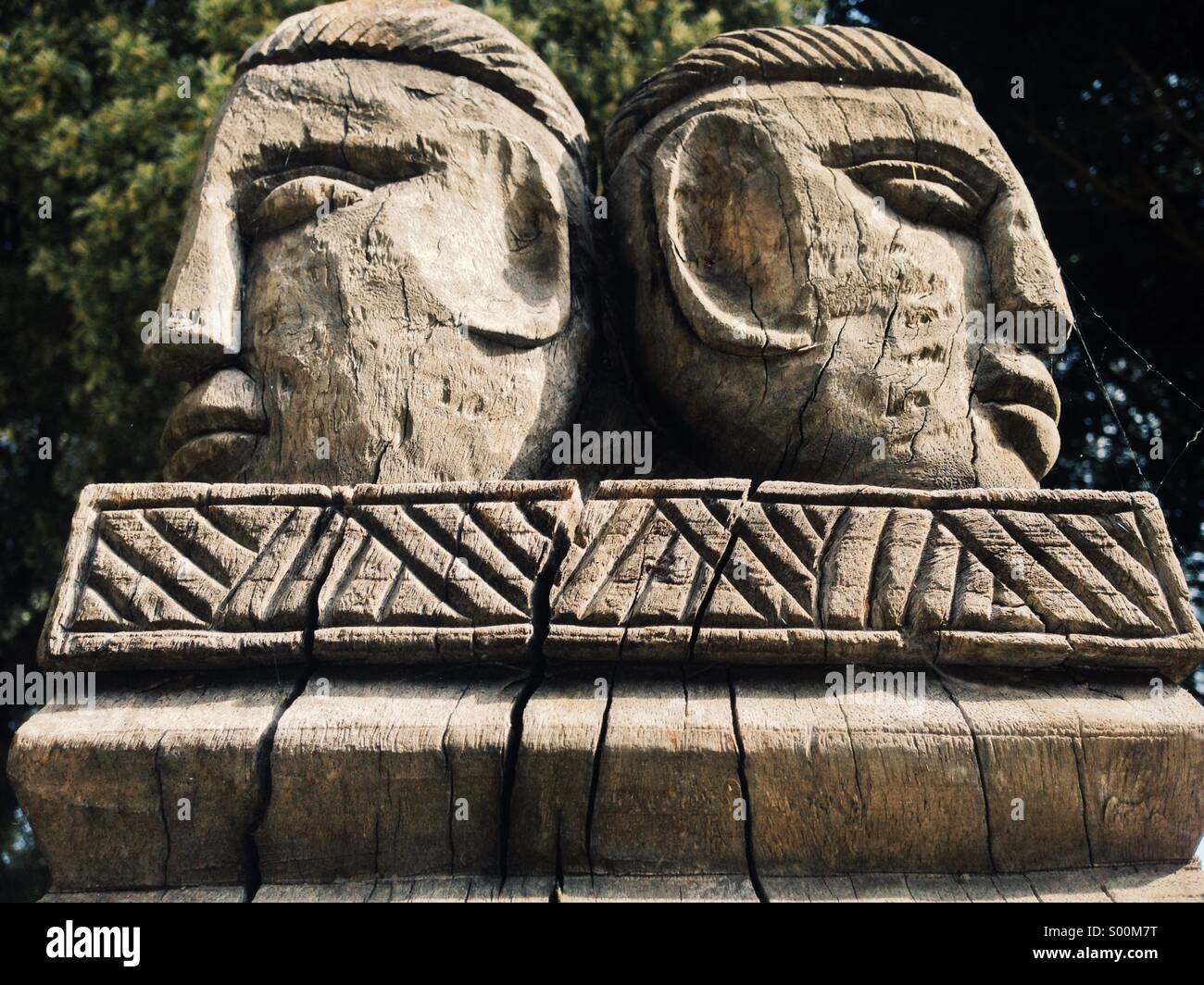 A make and female carved wooden head on top of a totem in Cyprus Stock Photo