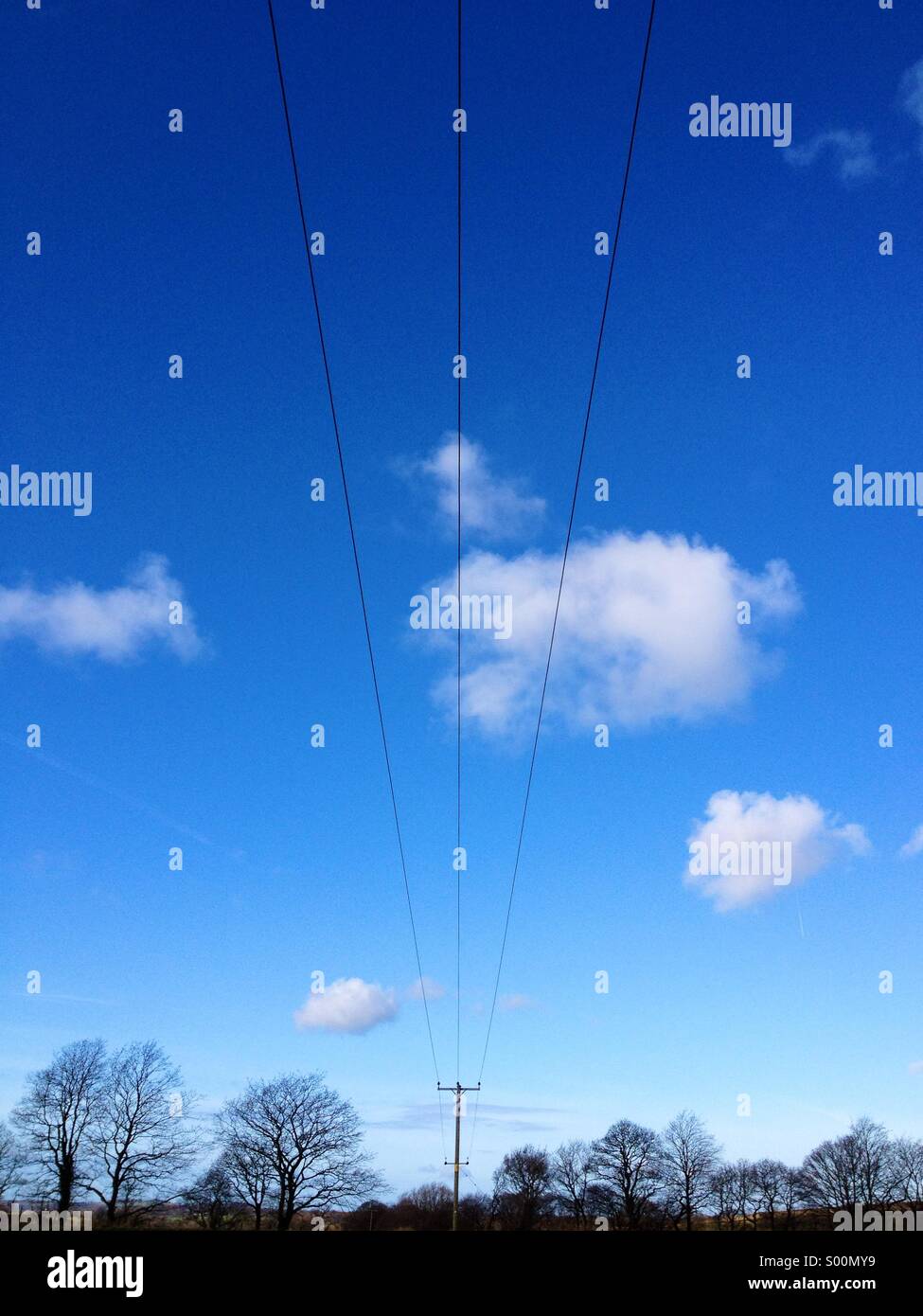 Electricity pylon against blue sky and clouds Stock Photo - Alamy