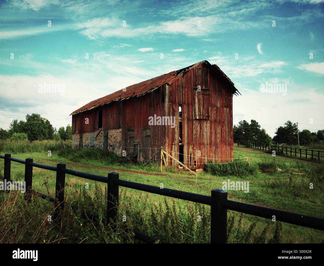 Red delapidated classic wood barn in Sweden. - Smartphone Captured Stock Image