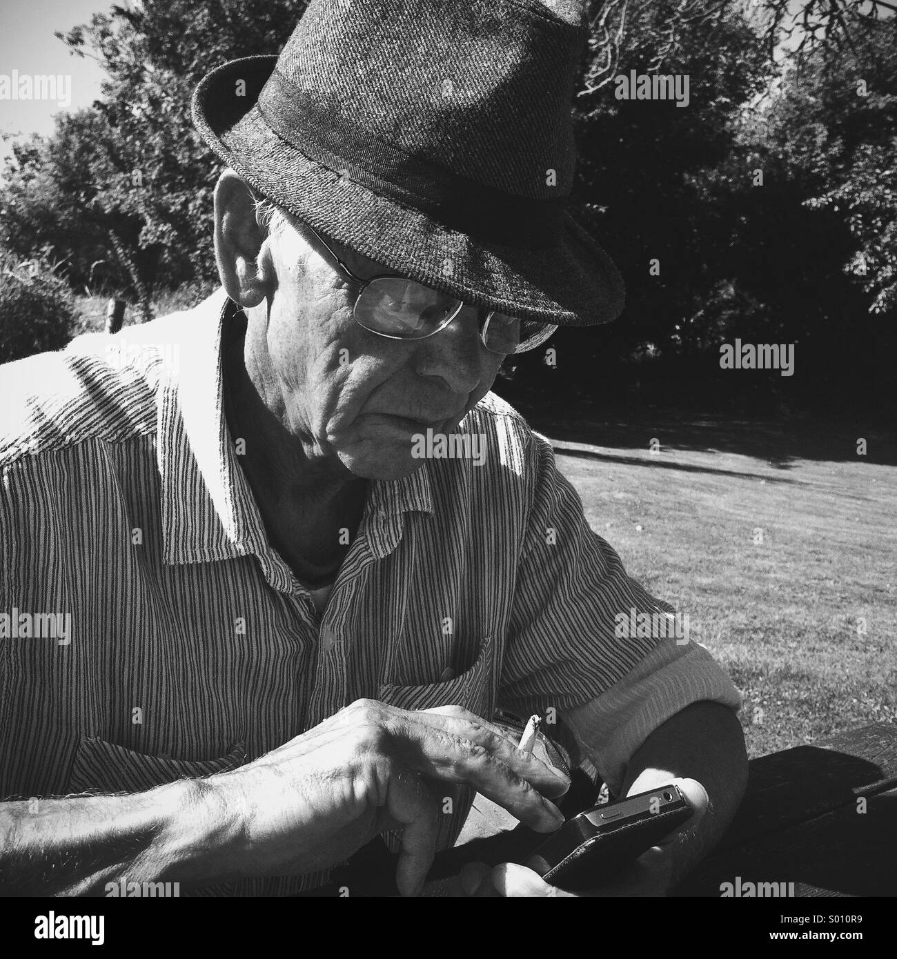 Older man playing on smart phone Stock Photo
