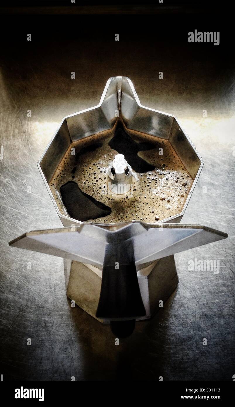 A top-down view captures the iconic octagonal shape of a Bialetti Moka pot, its lid open to reveal freshly brewed, dark coffee inside. - Smartphone Captured Stock Image