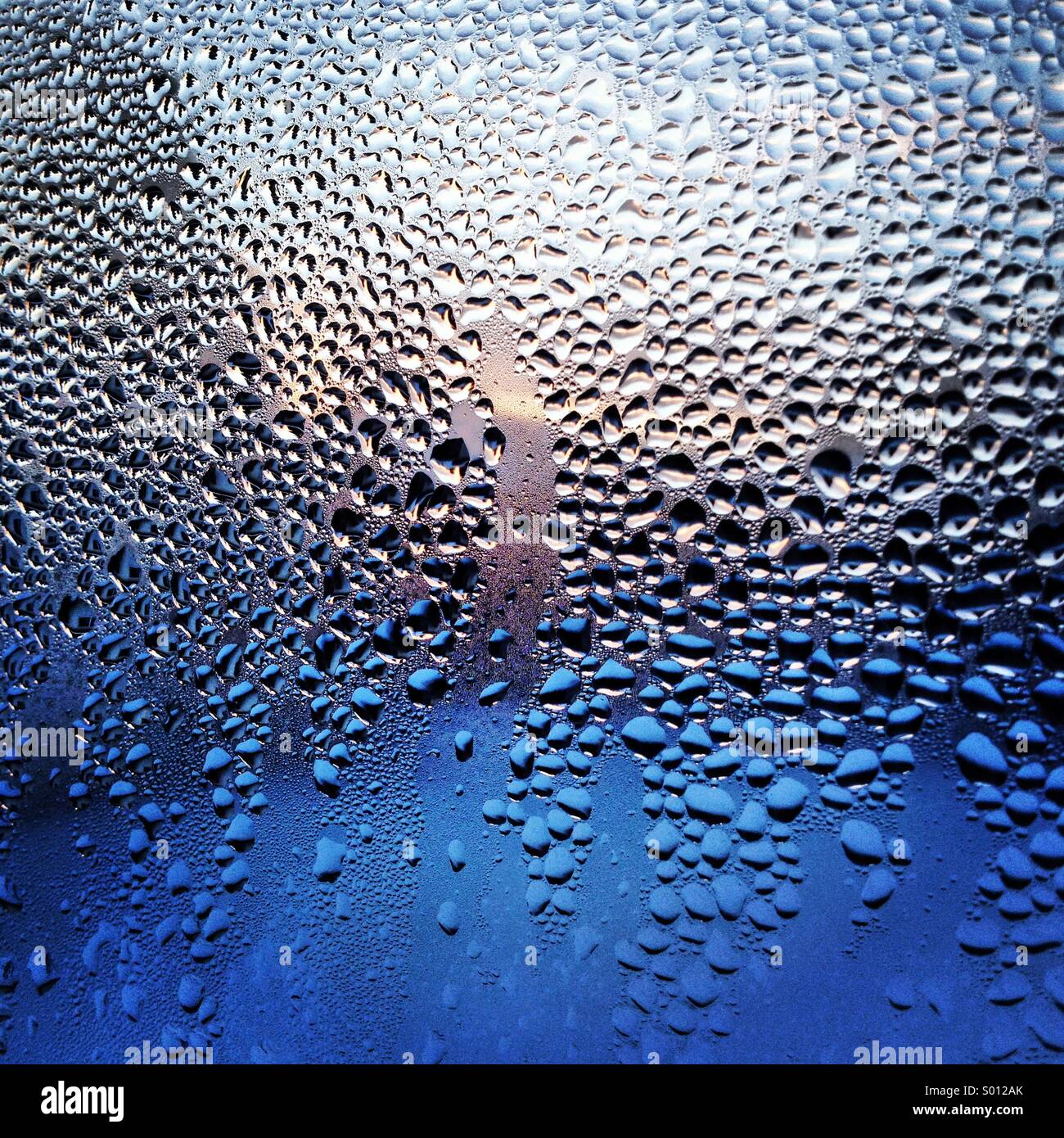 Condensation on a window during a winter sunrise Stock Photo