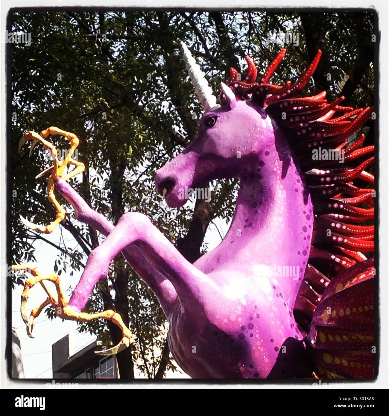 An giant Mexican alebrije, a fantastic animal in the form of a pink unicorn, is displayed in Alvaro Obregon avenue in Colonia Roma, Mexico City, Mexico - Smartphone Captured Stock Image