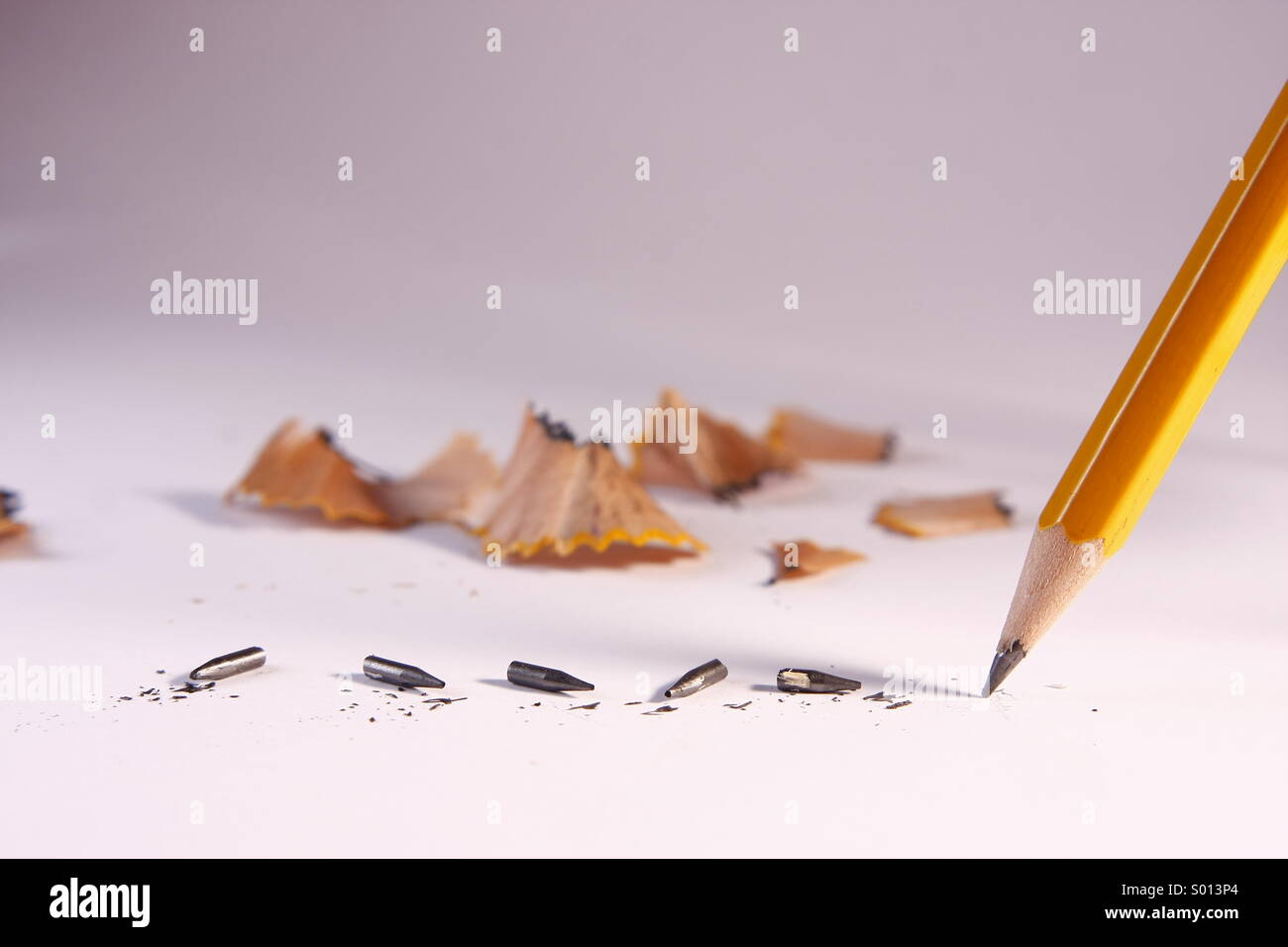 Pencil with broken lead tips and pencil shavings Stock Photo