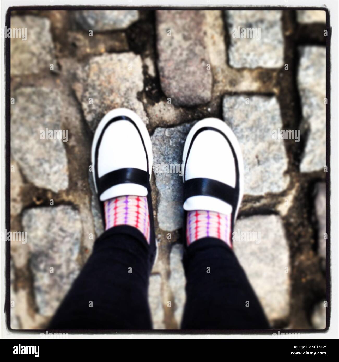 Vintage monotone shoes on cobbled pavement Stock Photo