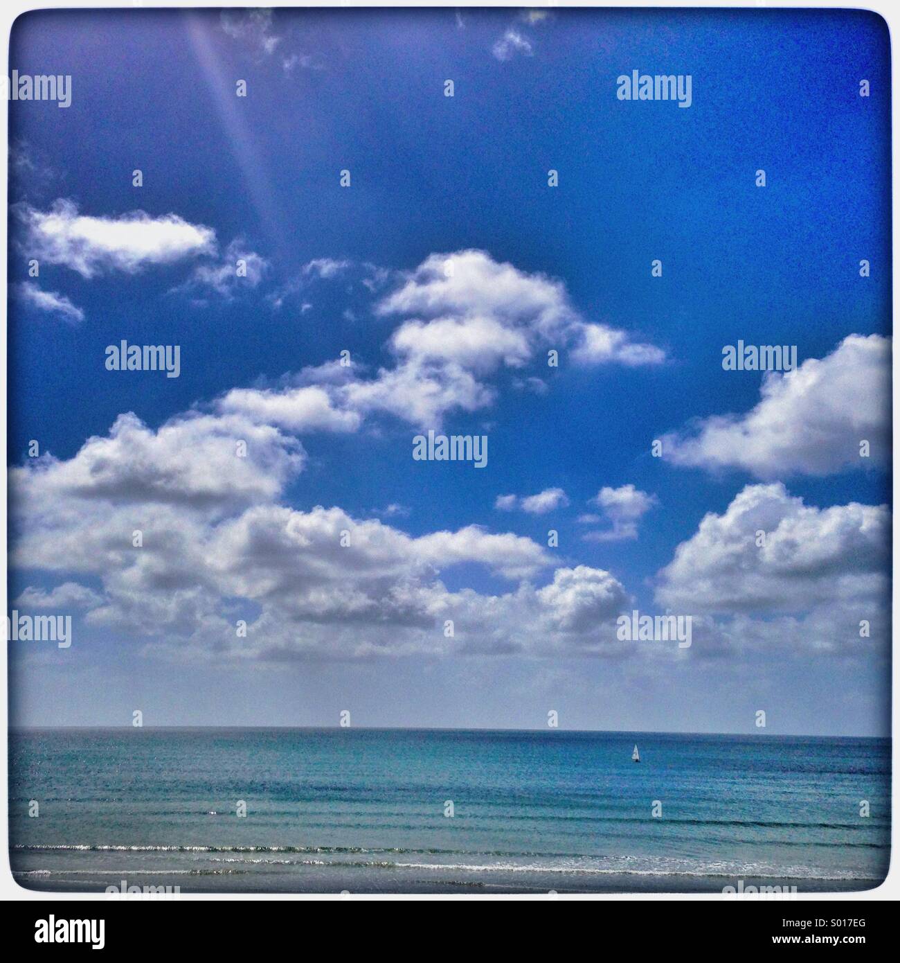 Sunny day at the beach with white puffy clouds Stock Photo - Alamy