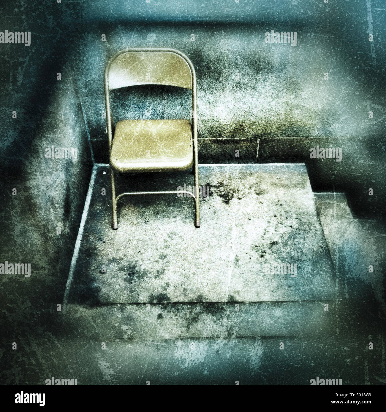 A metal folding chair sitting on a distressed looking cement stoop - Smartphone Captured Stock Image