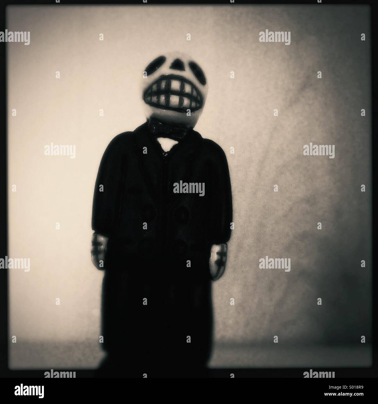 Whimsical clay skull figure in a clack suit. - Smartphone Captured Stock Image