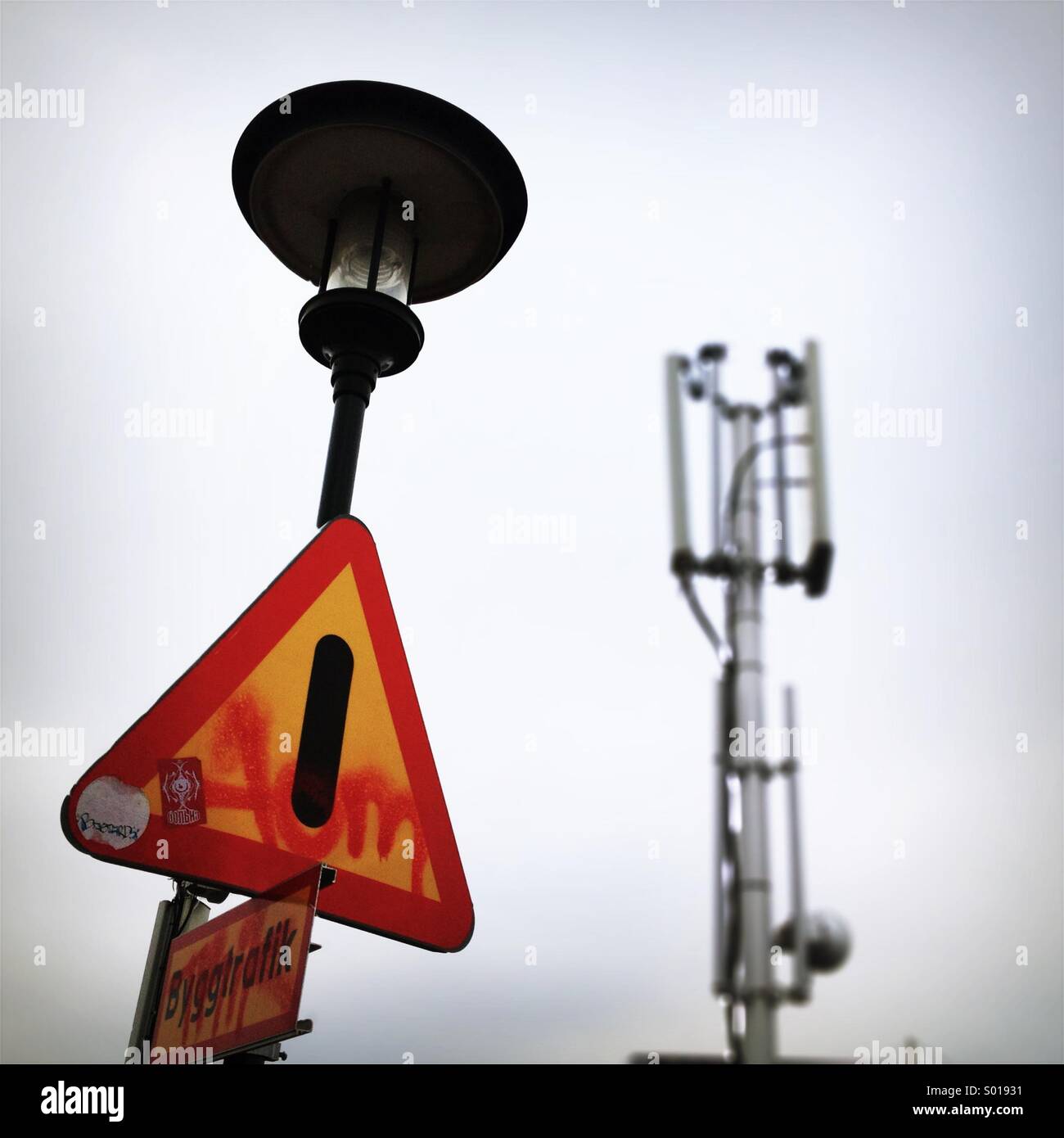 Sign and lamp in front of mobile telephone transmission mast. - Smartphone Captured Stock Image