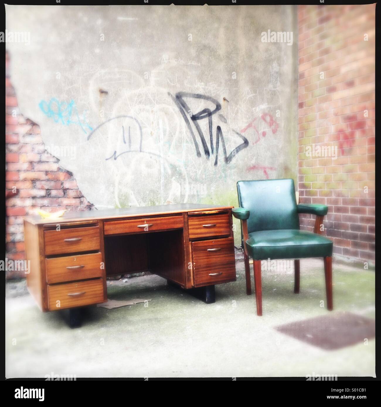 Vintage style wooden office desk and chair left on the street Stock