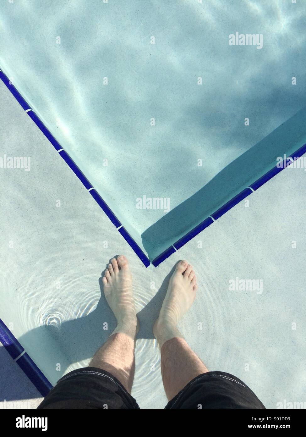 A selfie in a swimming pool. Looking down at a man's feet standing in a pool in Florida, USA. - Smartphone Captured Stock Image