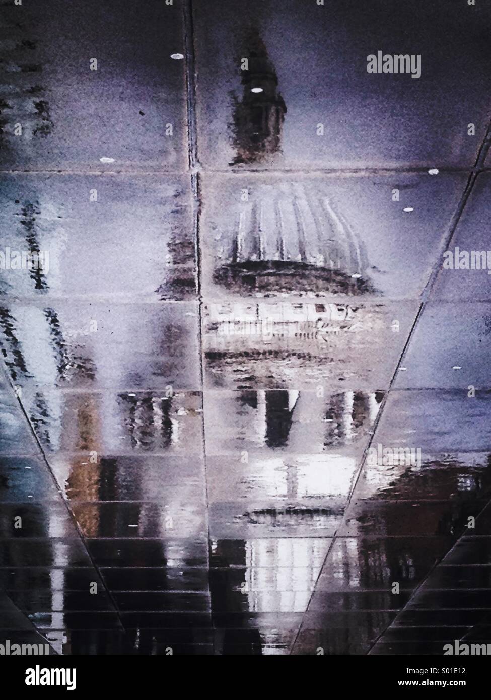 St Paul's Cathedral reflected in the puddles of a wet pavement - Smartphone Captured Stock Image