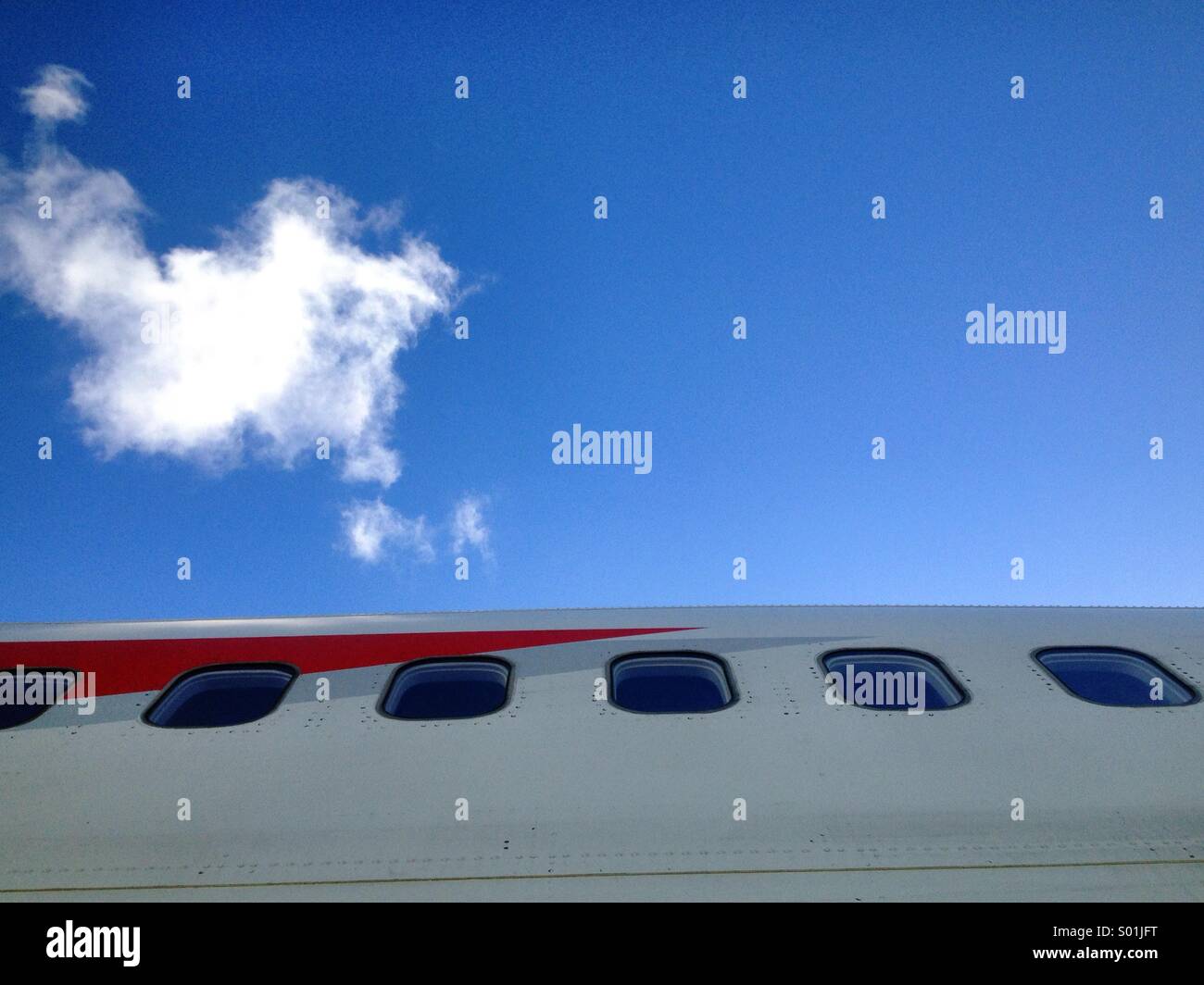 Windows on the side of a British Airways Boeing 747 against a blue sky. Stock Photo