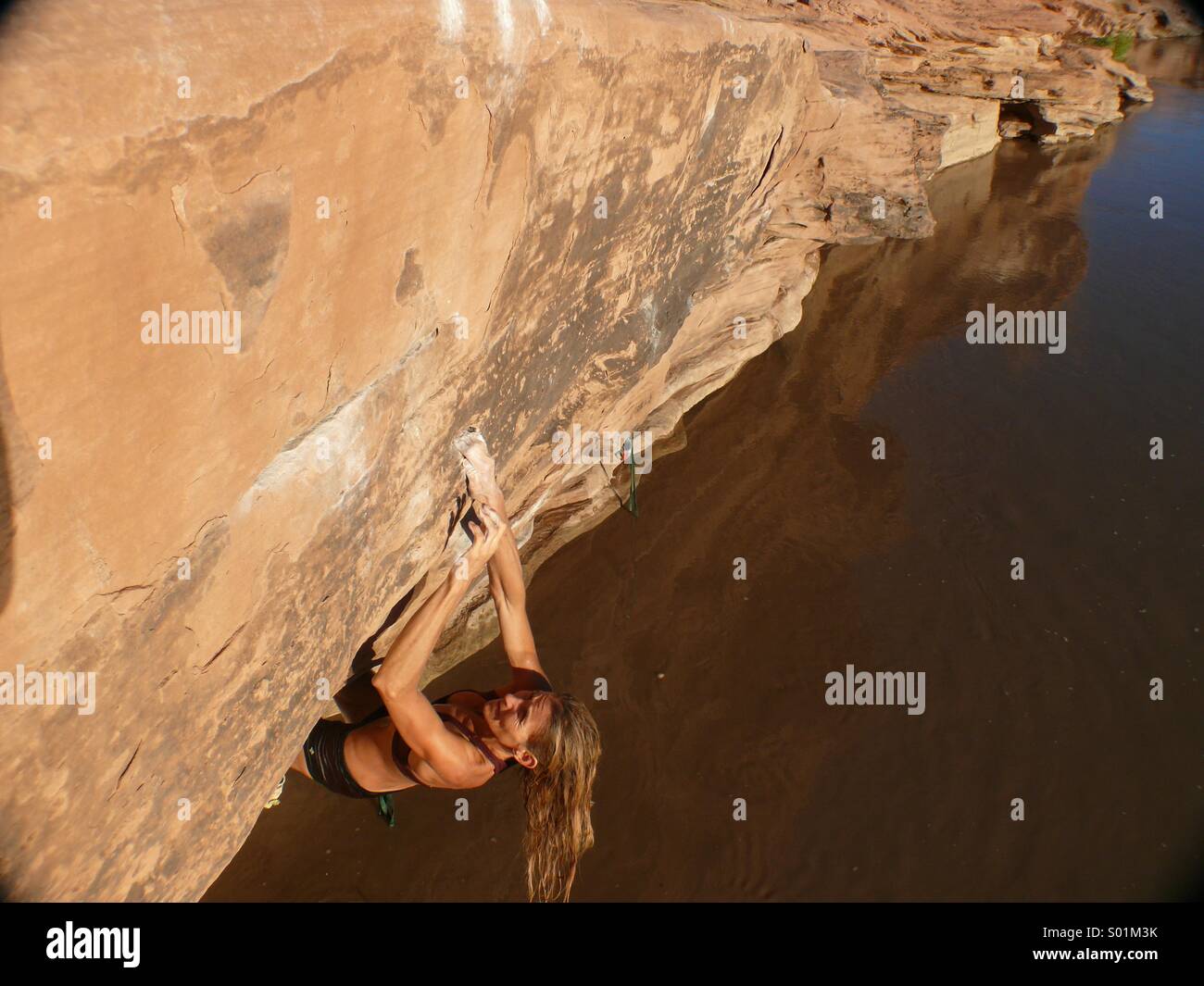 Woman climbing, bouldering over water Stock Photo Alamy