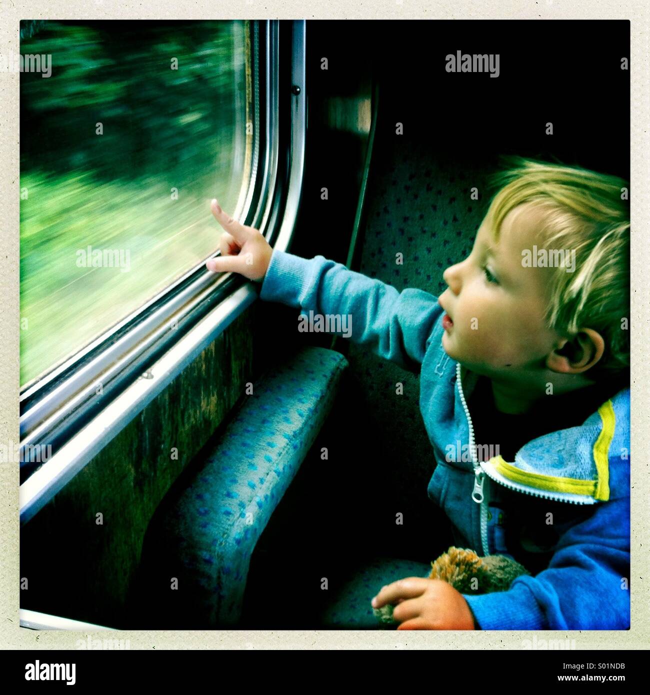 Young boy looking out of a train window, UK Stock Photo