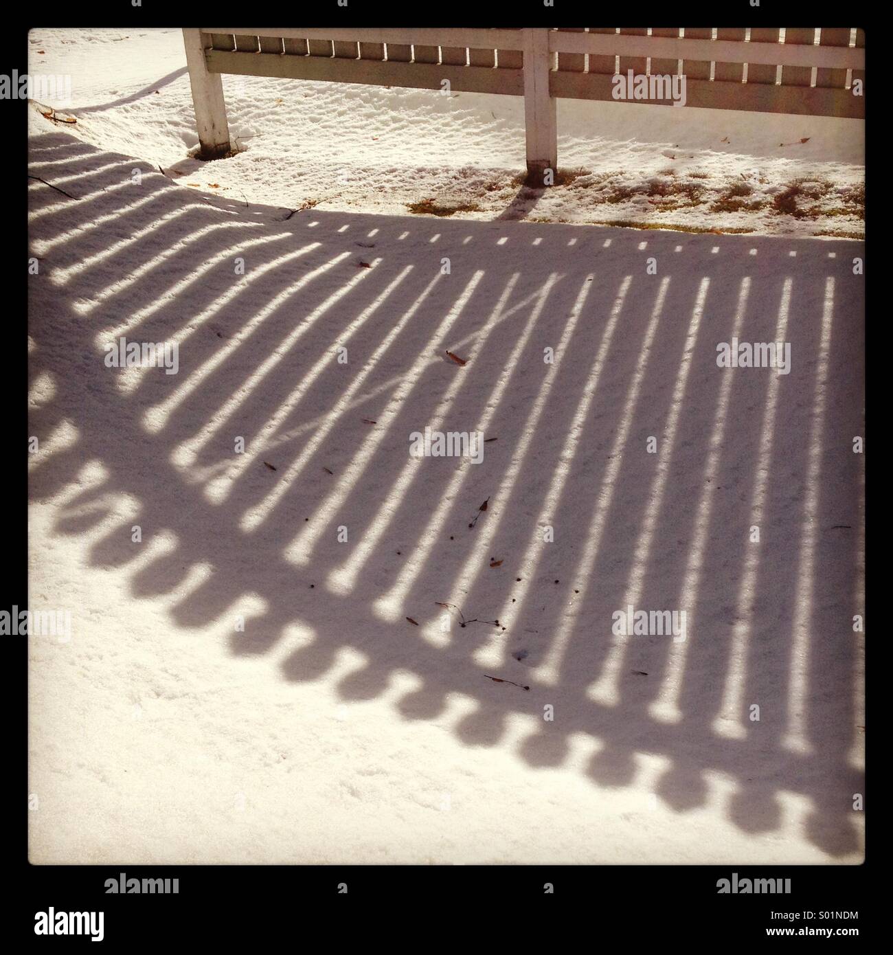 The shadow of a fence on snow in low winter sunshine... - Smartphone Captured Stock Image