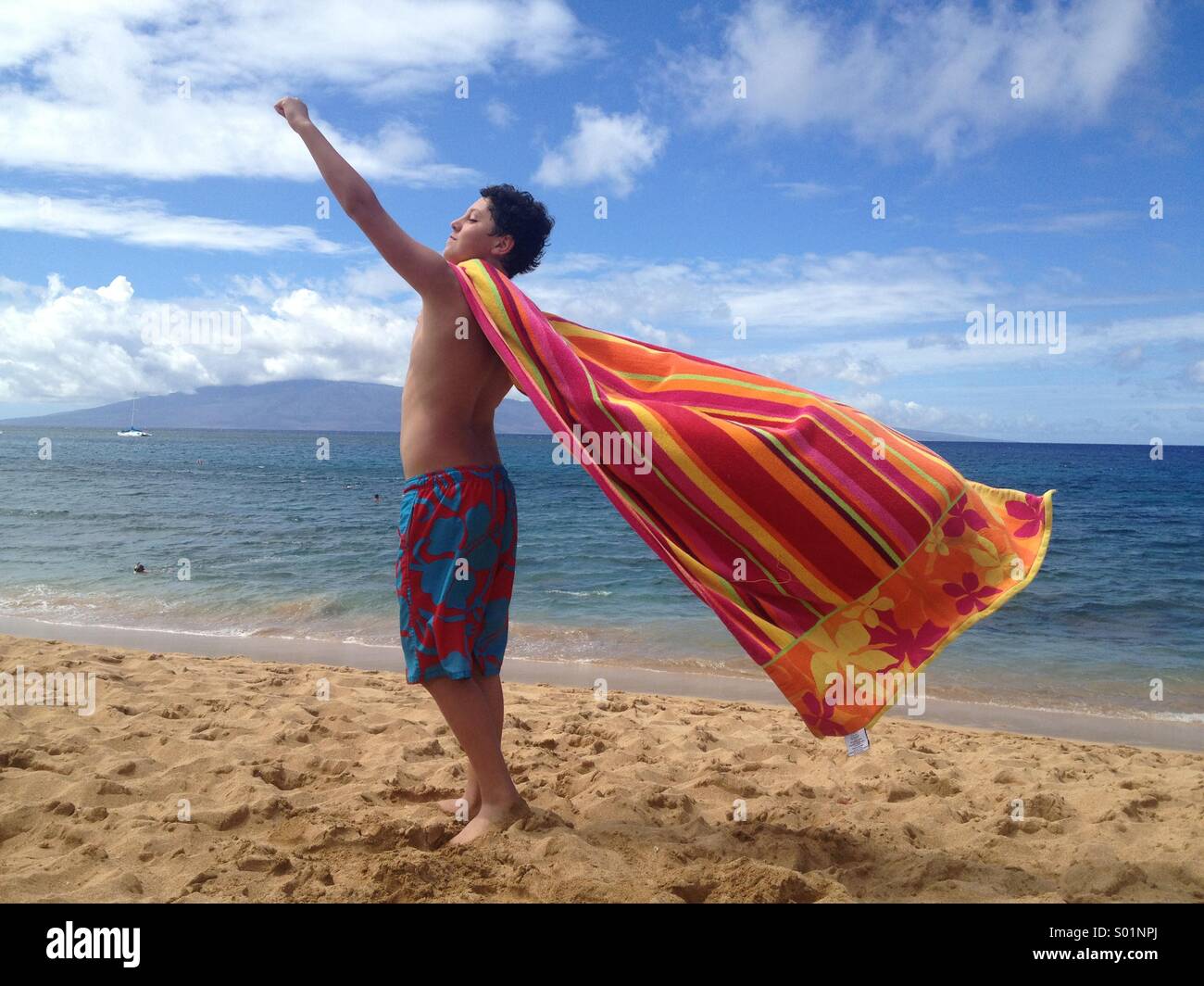 Boy, aged 12, playing with beach towel, Hawaii Stock Photo