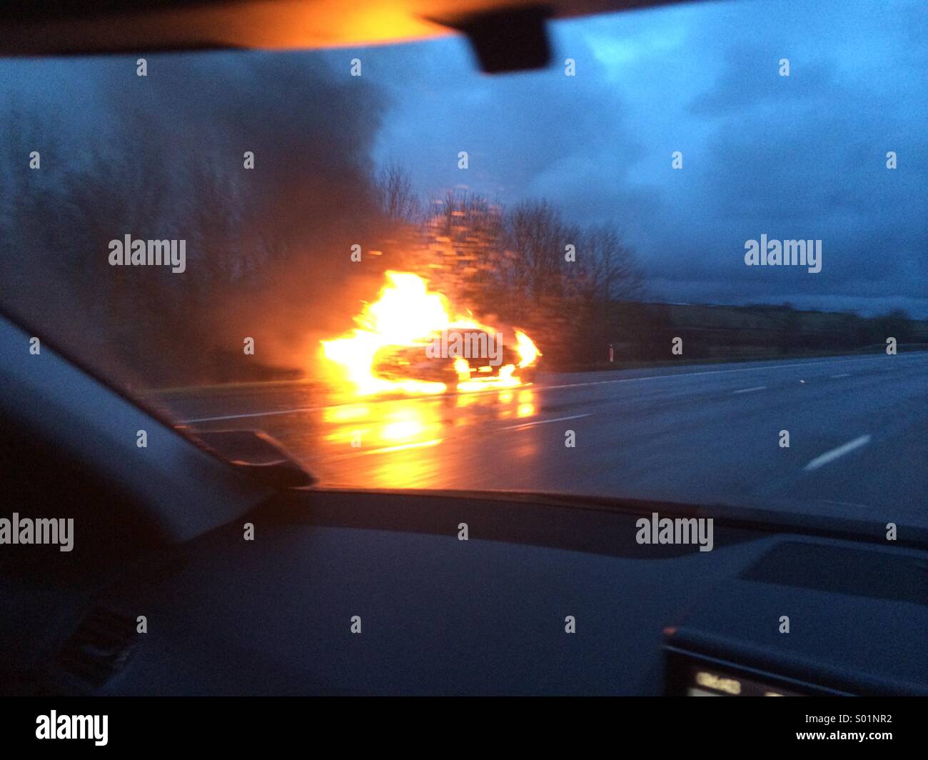 Car on fire on hard shoulder of motorway Stock Photo Alamy