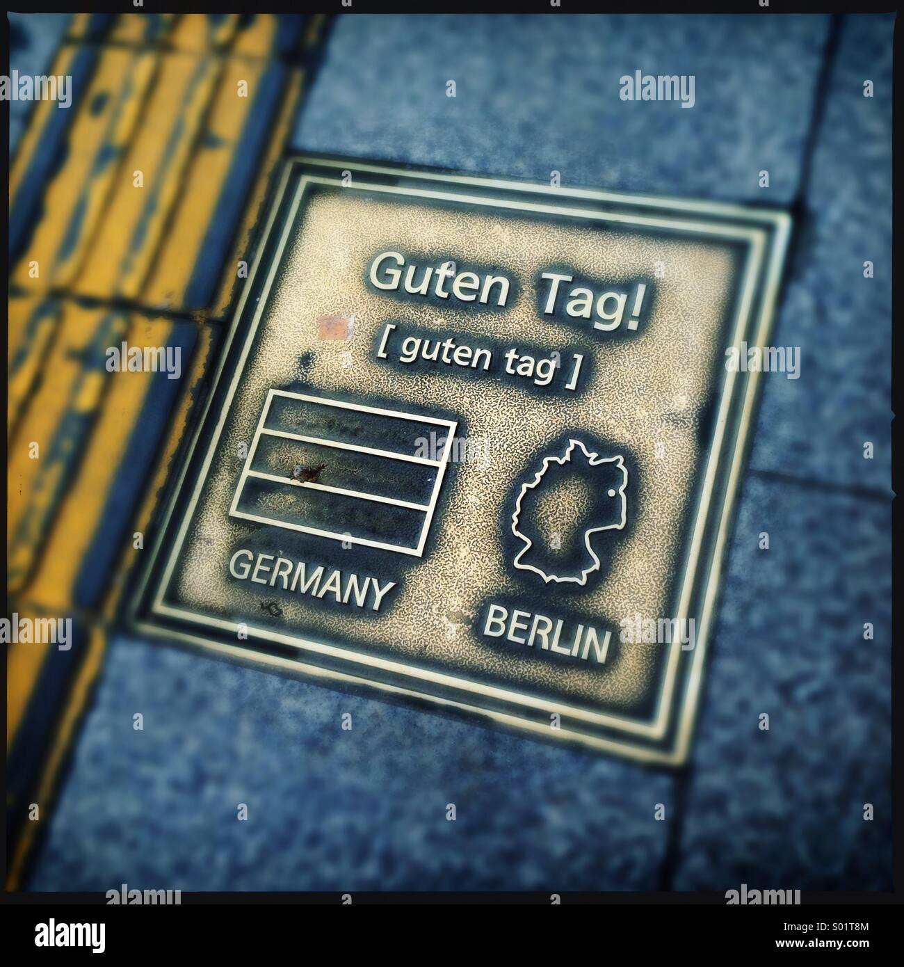 Brass plate on sidewalk showing hello in german Stock Photo