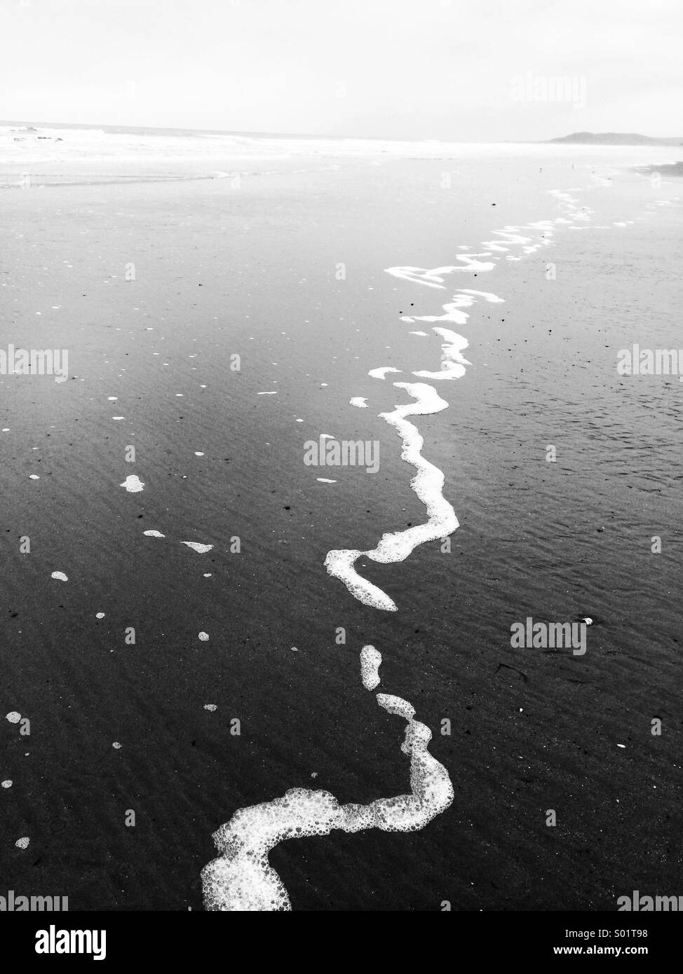 Tide foam on beach Stock Photo