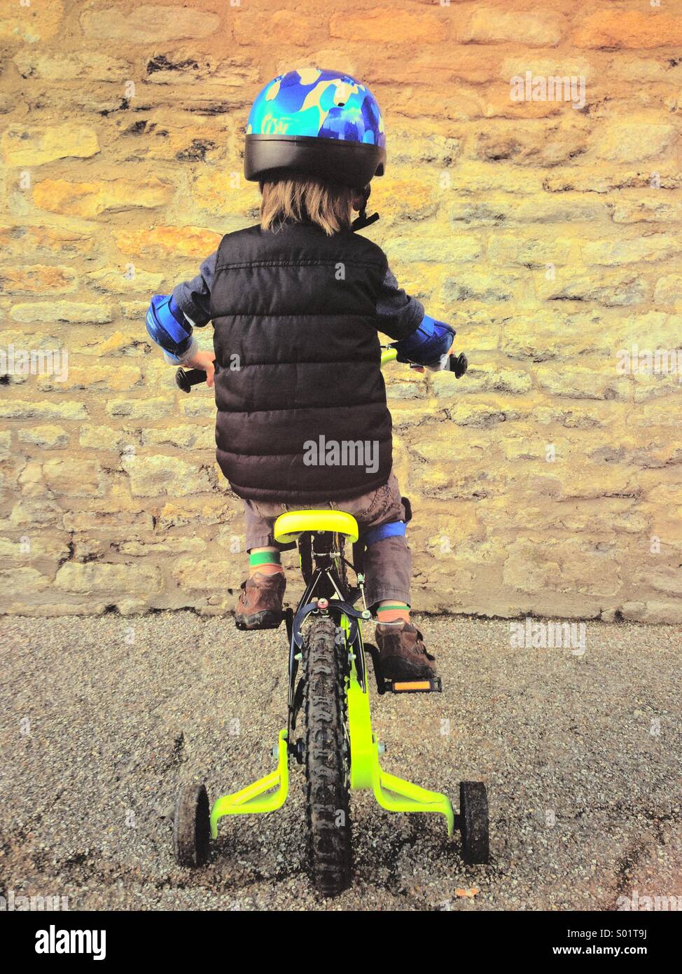 Rear view of 4 year old boy riding small bicycle into a stone wall. Dead end. Going nowhere. Photo Credit - © COLIN HOSKINS. - Smartphone Captured Stock Image Rear view of 4 year old boy riding small bicycle into a stone wall. Dead end. Going nowhere. Photo Credit - © COLIN HOSKINS. - Smartphone Captured Stock Image
