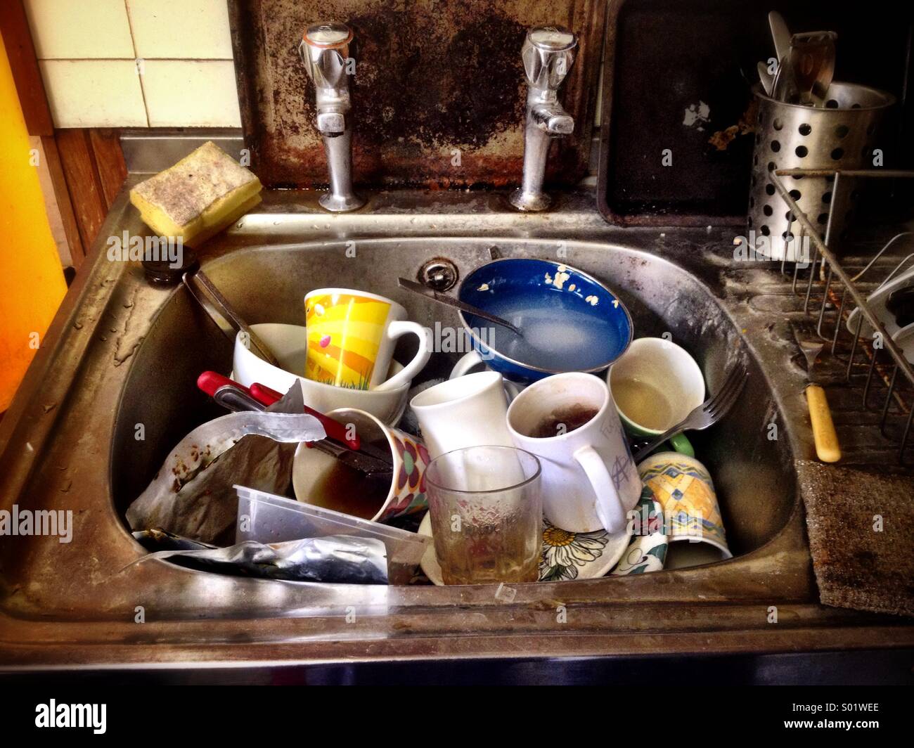 Washing up in a squalid student flat Stock Photo