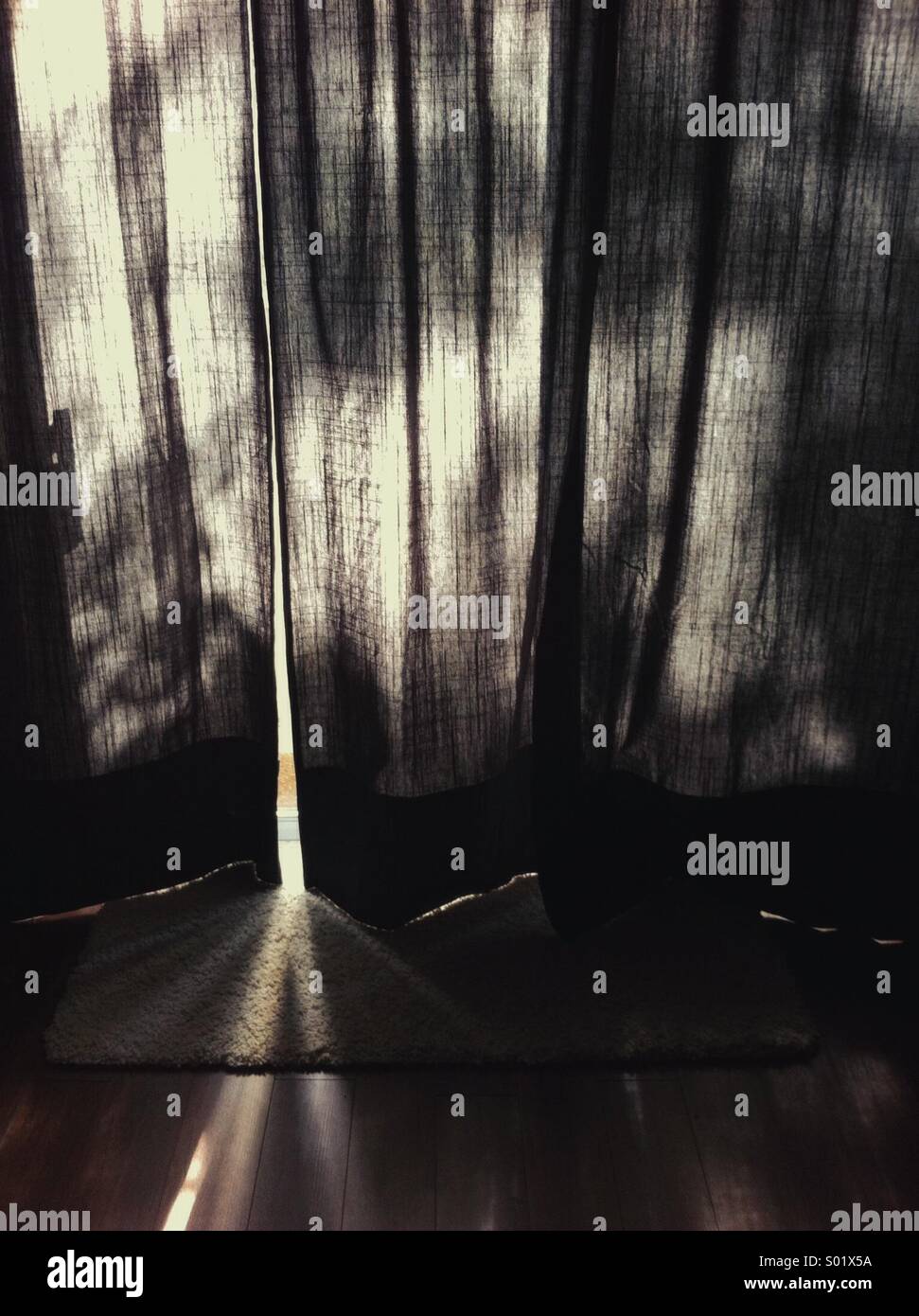 Sunlight and deep shadows filtered through dark curtains. - Smartphone Captured Stock Image