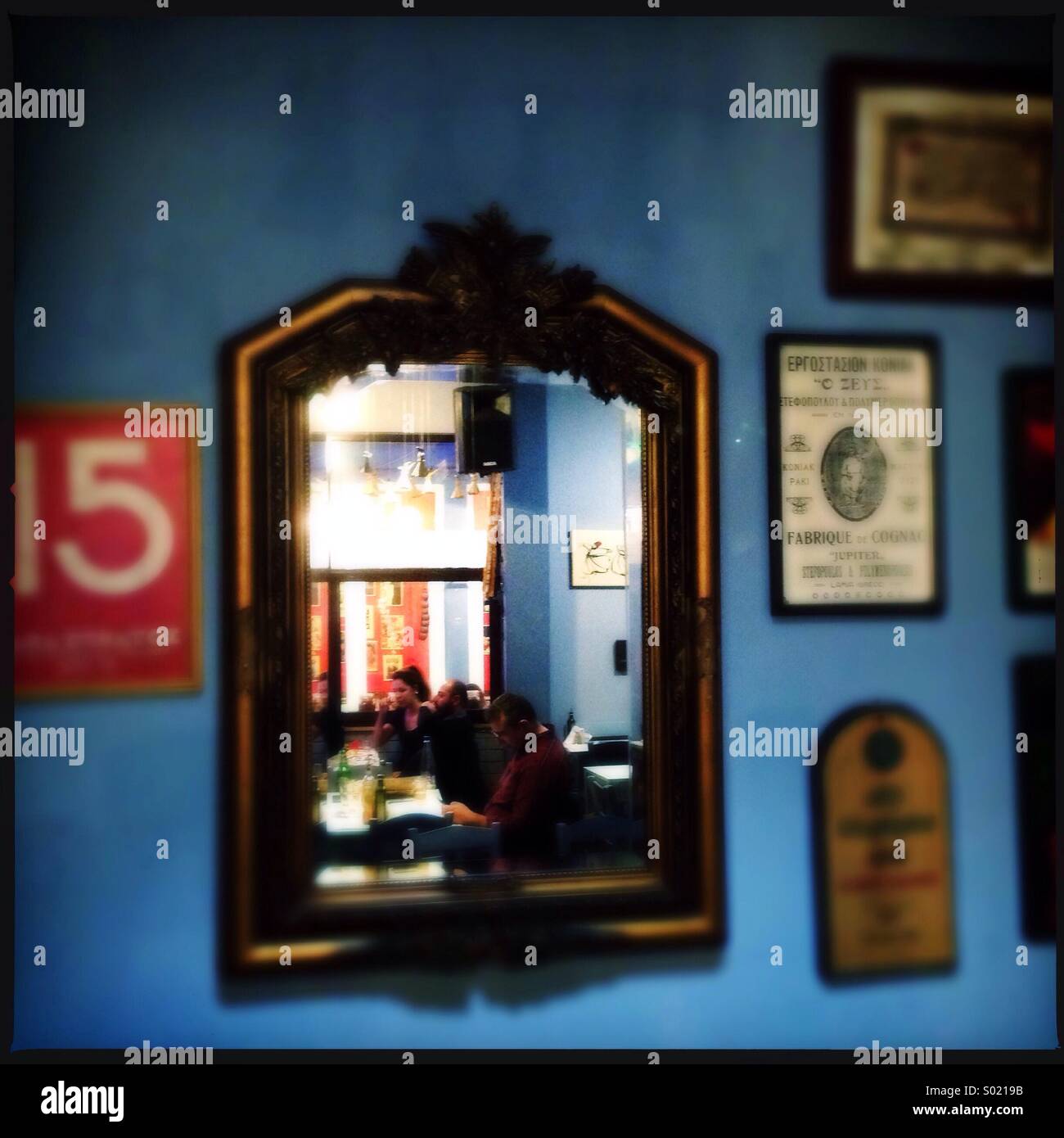 Greek restaurant wall with mirror and posters - Smartphone Captured Stock Image