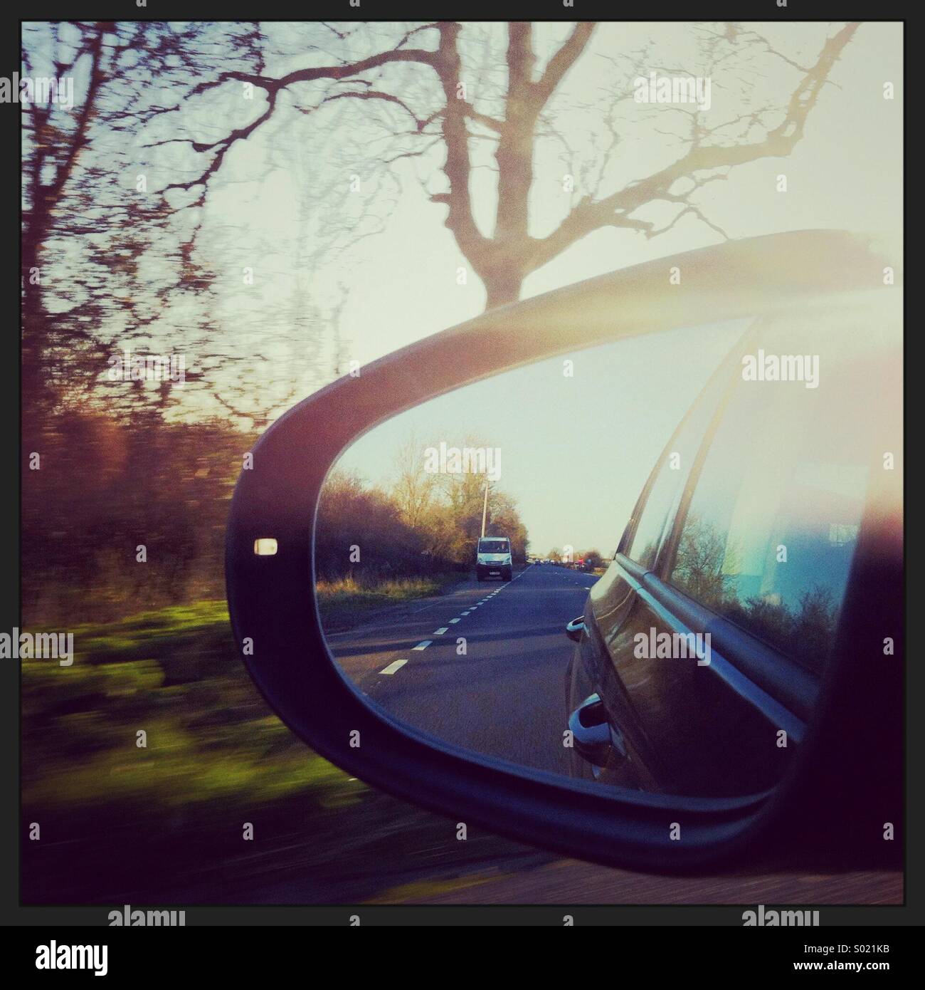 View of the reflection in a car wing mirror on a journey in the UK. - Smartphone Captured Stock Image
