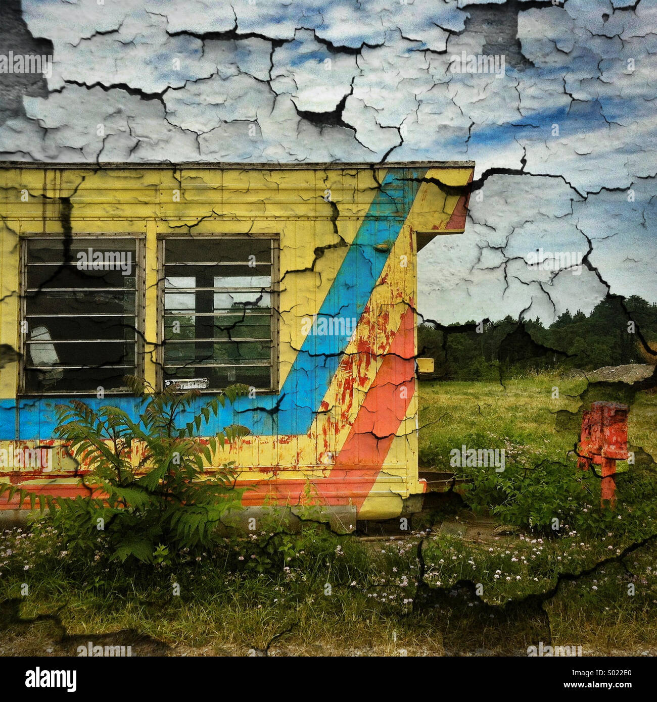 An image of a colorful abandoned trailer is enhanced with a peeling paint effect Stock Photo