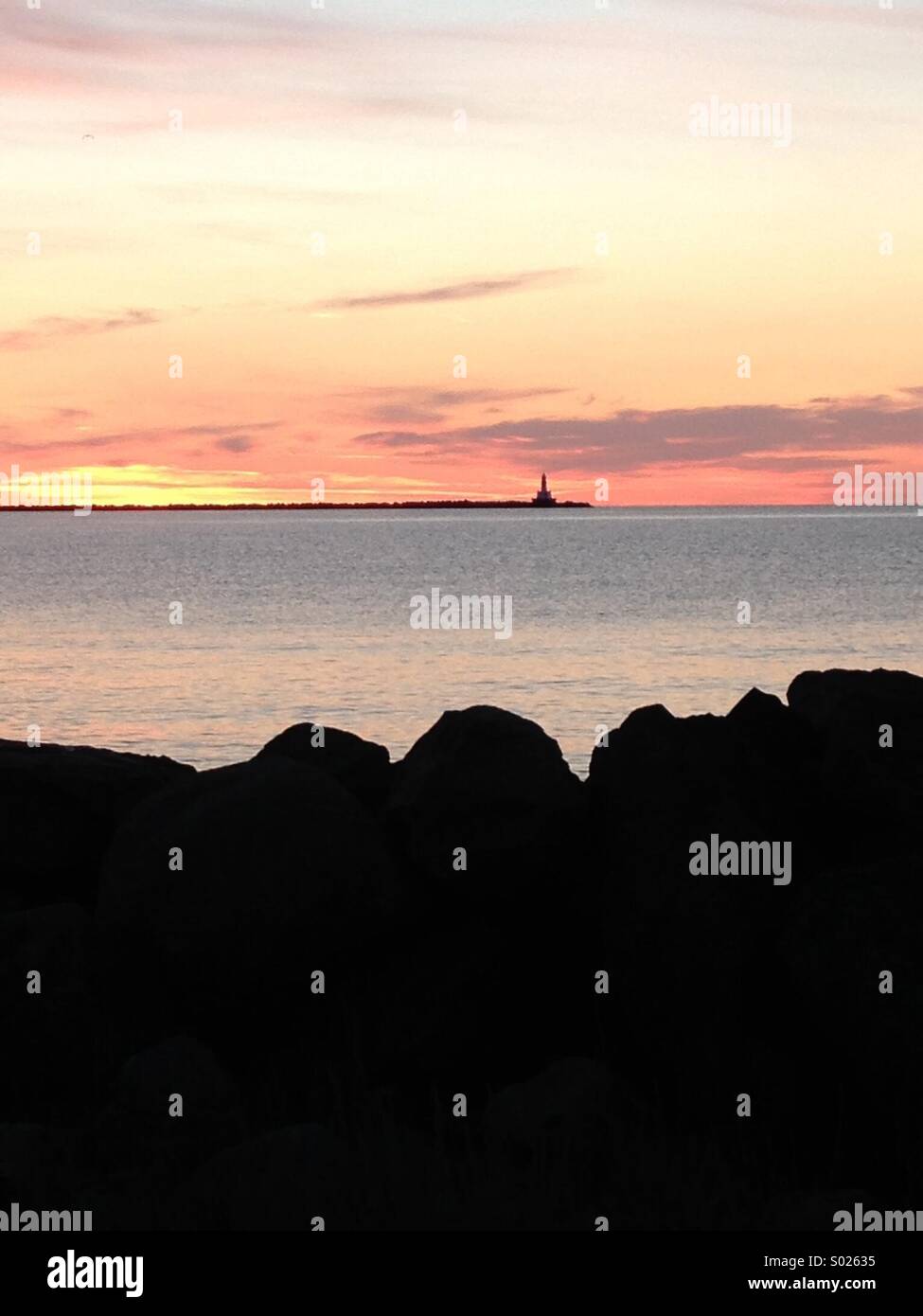 Lighthouse silhouetted at sunrise on Lake Superior, Michigan - Smartphone Captured Stock Image