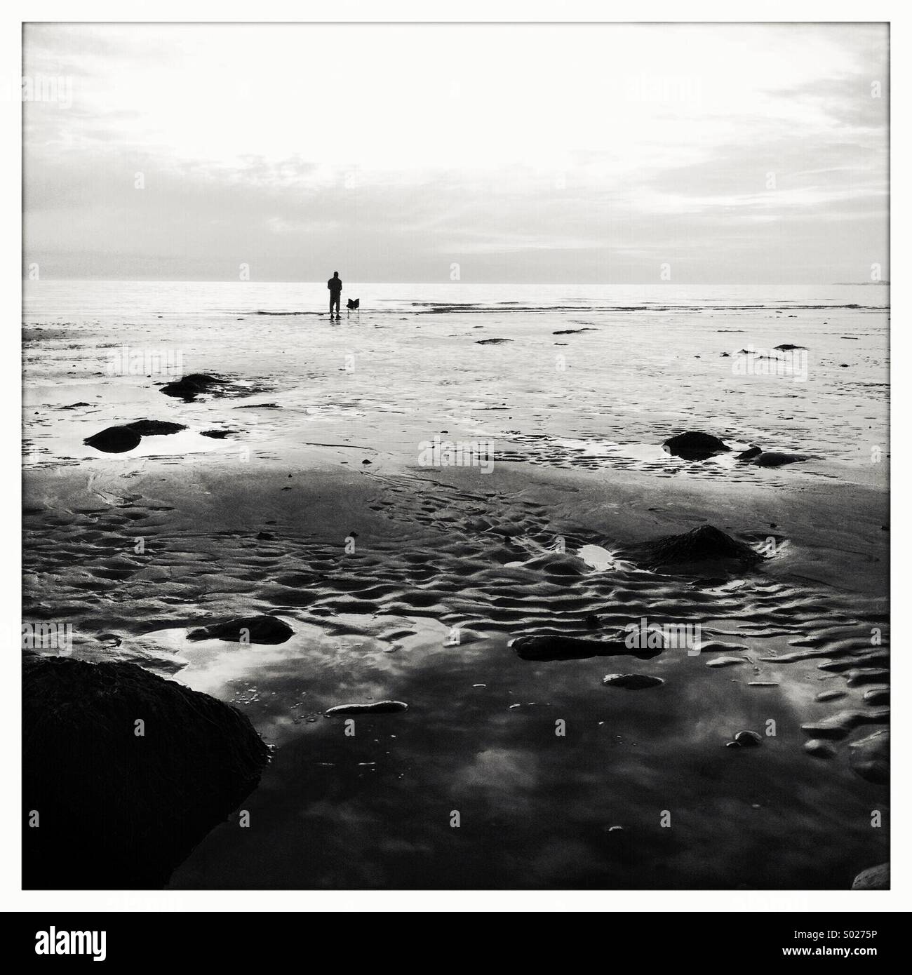 Fisherman on beach (black & white) Stock Photo