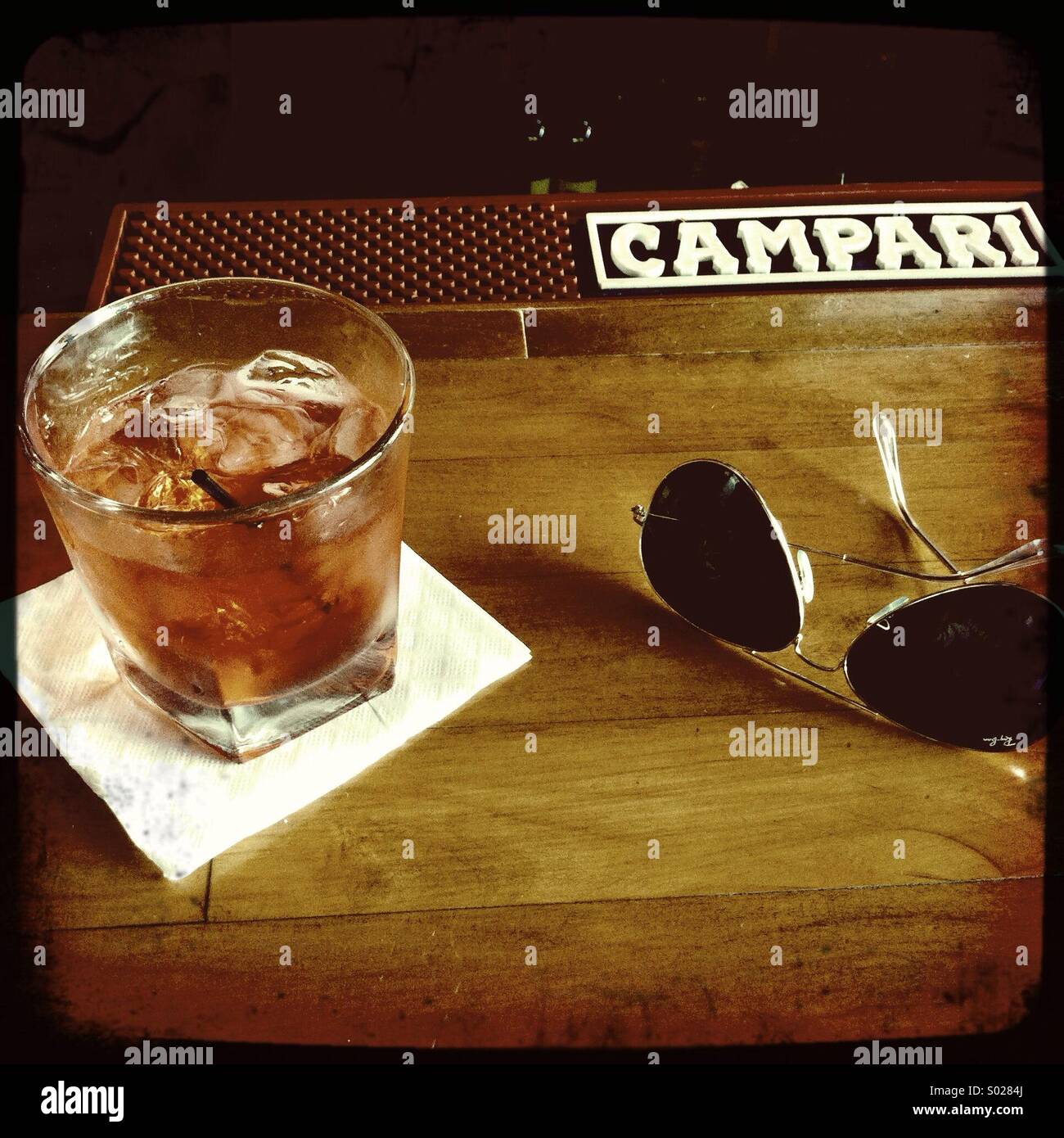 A pair of Ray-ban aviator sunglasses and a Negroni cocktail. - Smartphone Captured Stock Image