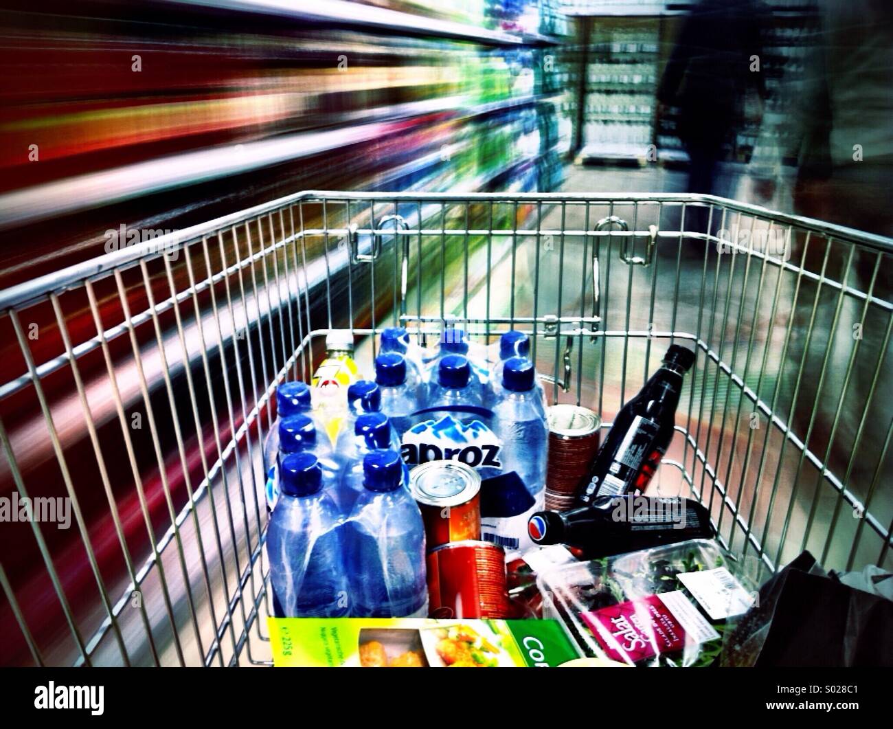 Shop till you drop - laden supermarket trolley speeds through a store. Shoppyland, Schönbühl, Switzerland Stock Photo