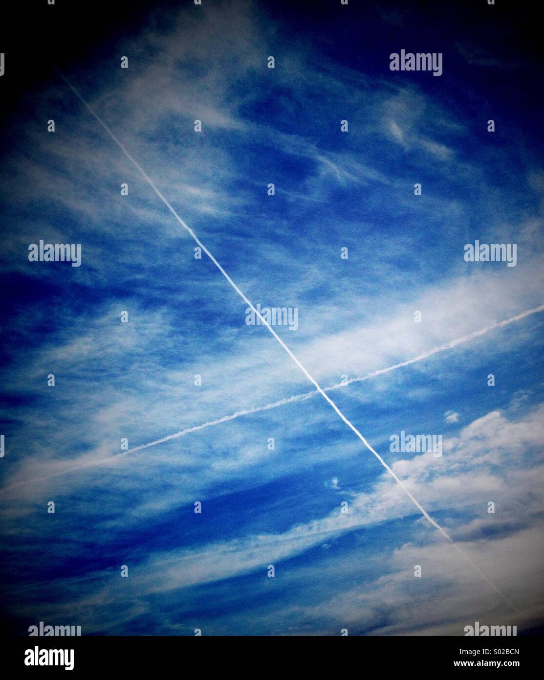 Contrail cross in sky Stock Photo