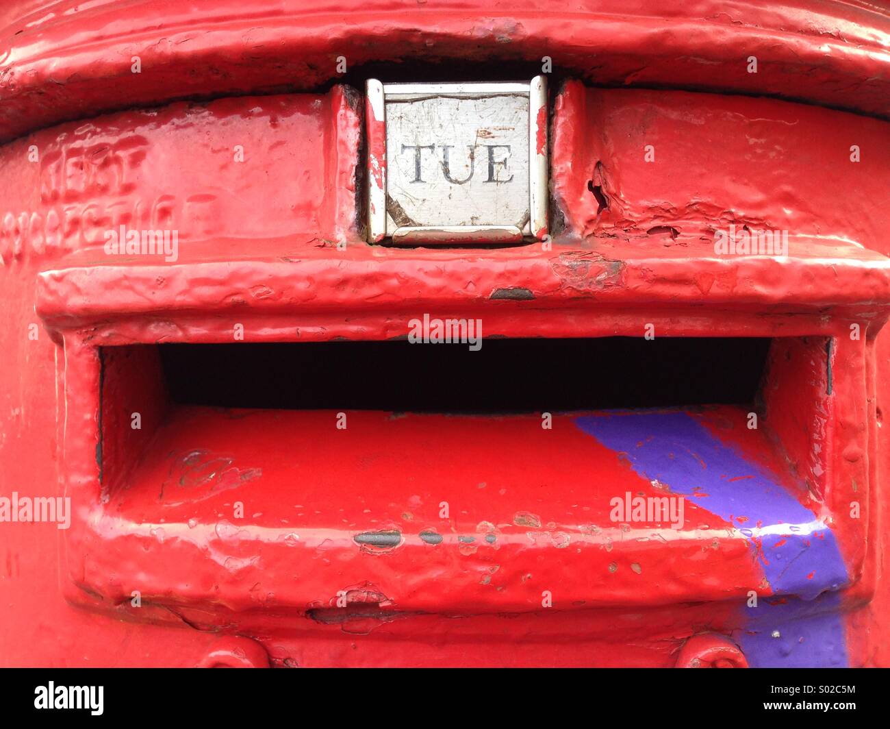 Royal Mail red pillar box defaced with purple paint dripping out of letter opening Stock Photo
