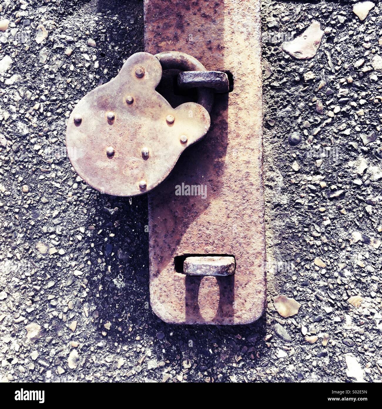 Rusting padlock on a concrete wall square-shaped image Stock Photo