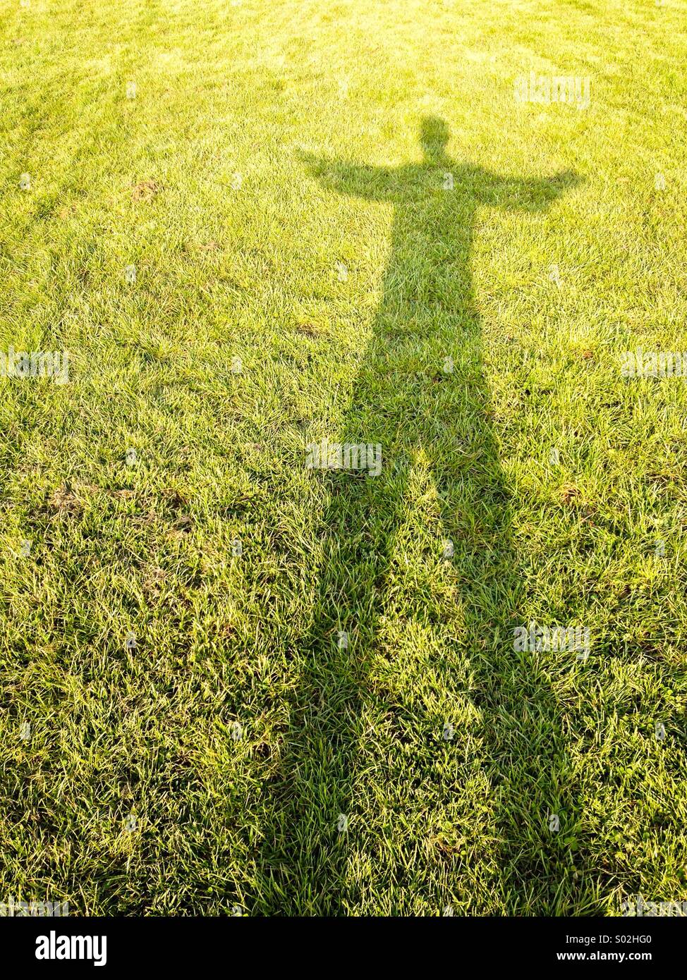 Long shadow of person on grass - Smartphone Captured Stock Image