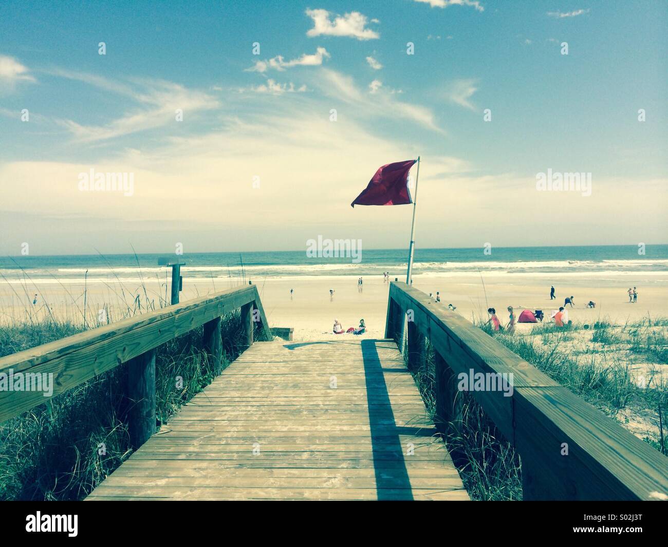 Red warning flag flying at Jacksonville Beach, Florida - Smartphone Captured Stock Image
