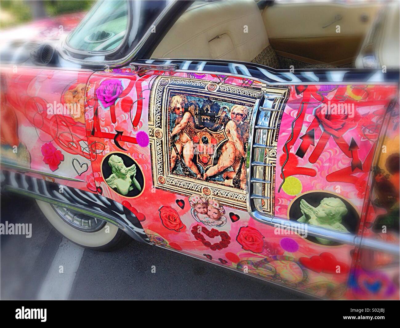 Love car. Detail of romantic paint job on sedan at public car show. Artwork features cuspids and other love symbols. Stock Photo