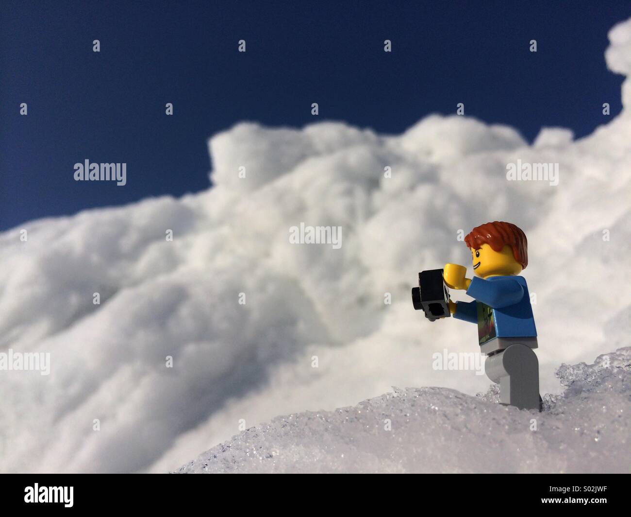 LEGO minifigure photographing a snow covered mountain in Norway Stock