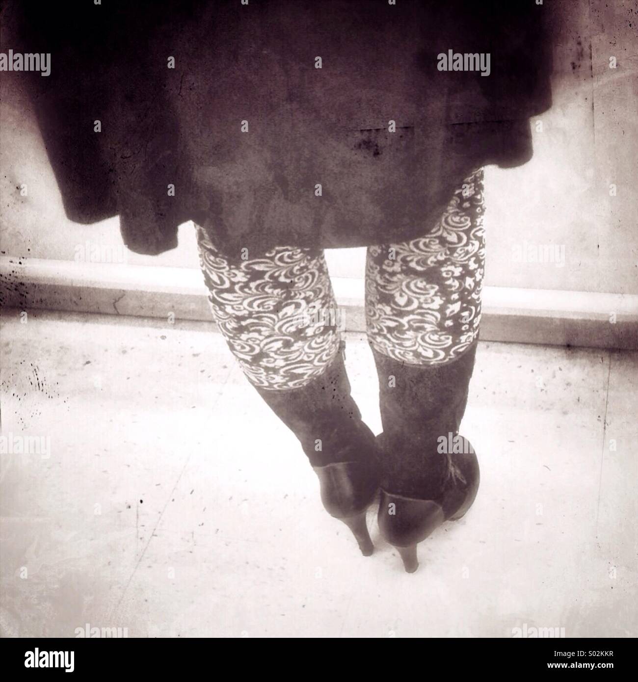 Patterned tights and high heeled boots on young woman - Smartphone Captured Stock Image