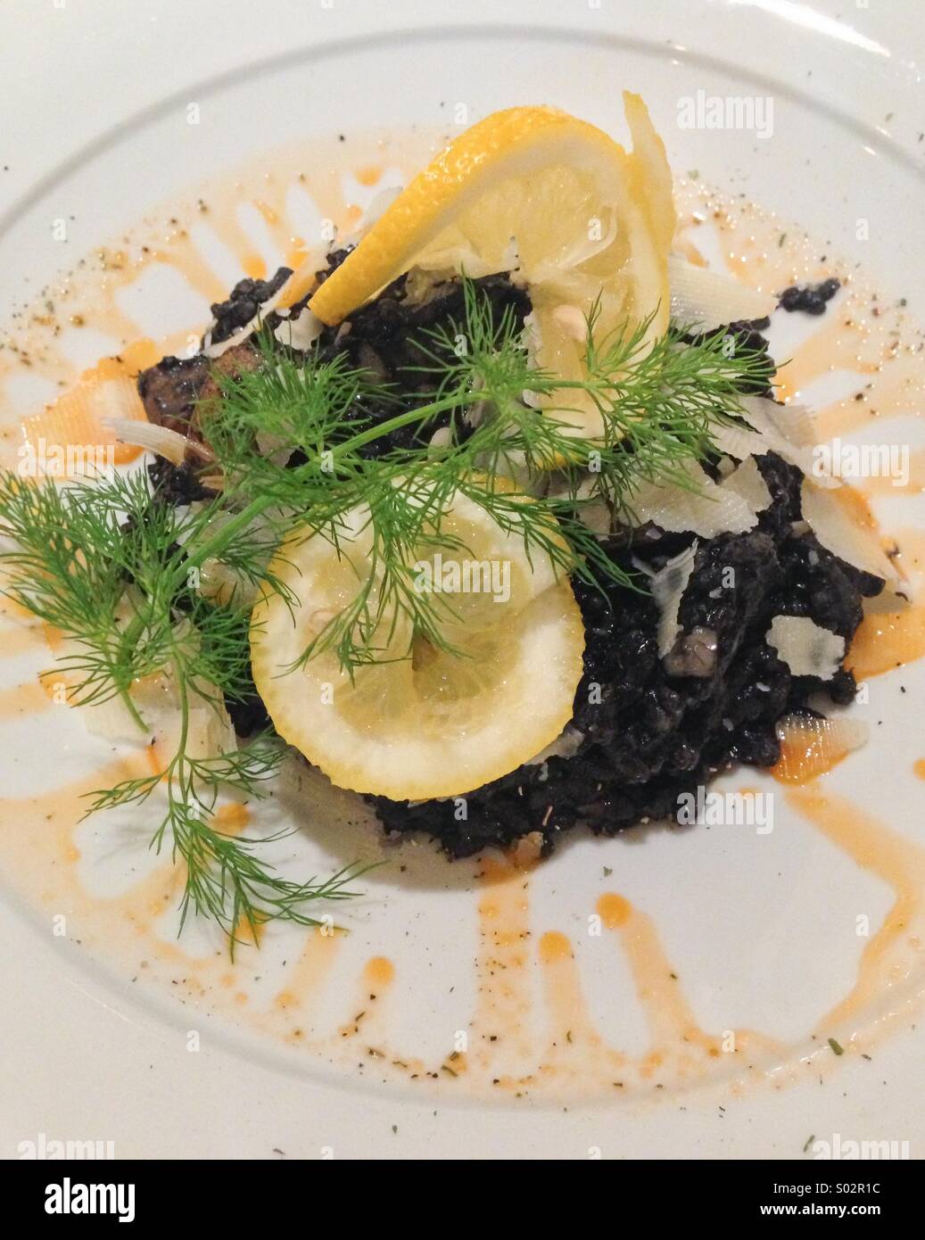 Black risotto with lemon and dill Stock Photo