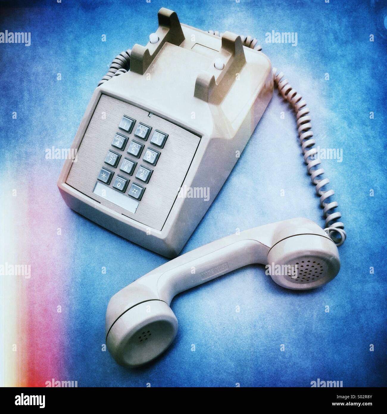 Punch button land line retro office phone with handset off. Stock Photo