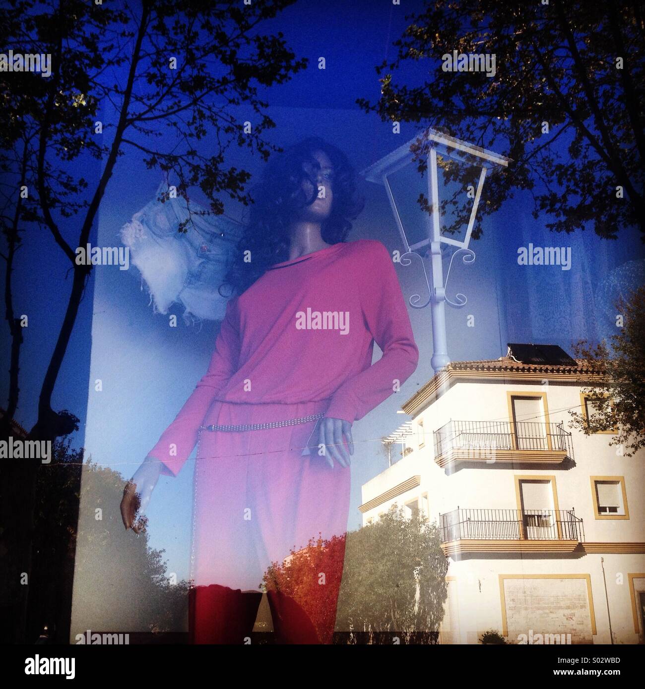 Mannequins decorate a window shop with a reflection of a street in Villamartin, Cadiz province, Andalusia, Spain - Smartphone Captured Stock Image