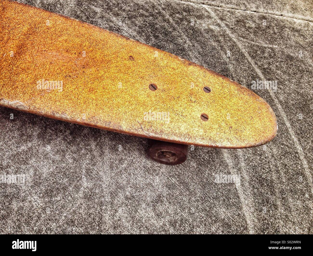 Vintage Skateboard on concrete with wheel marks. Stock Photo