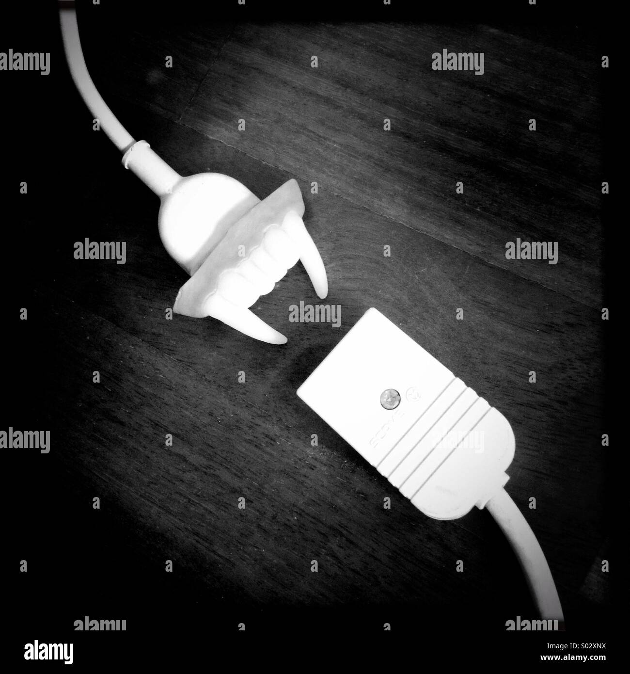 Energy sucker high energy consumption vampire concept surreal attack victim electric cable outlet funny image vampire dentures fossil - Smartphone Captured Stock Image