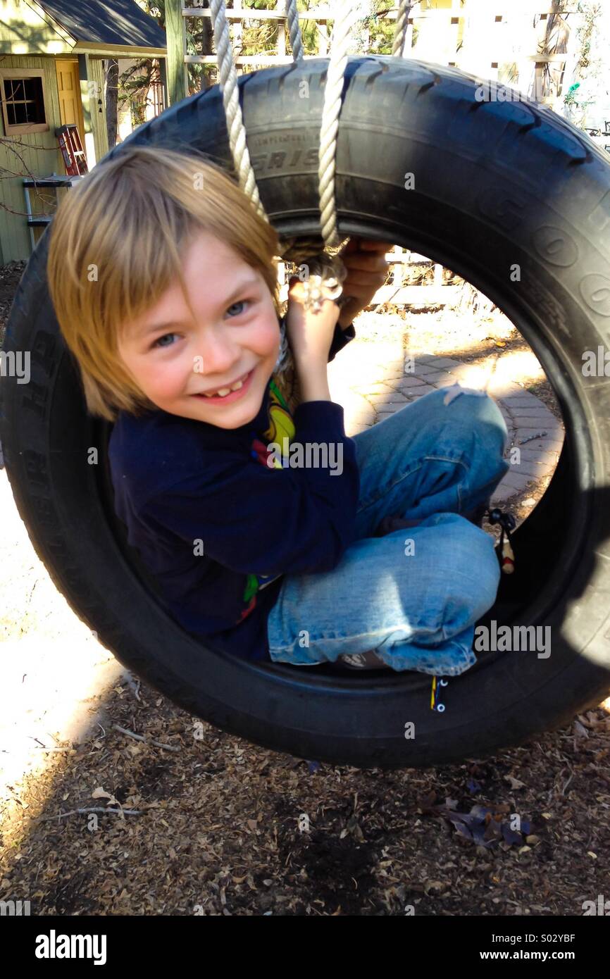 7 year old boy on a tire swing Stock Photo